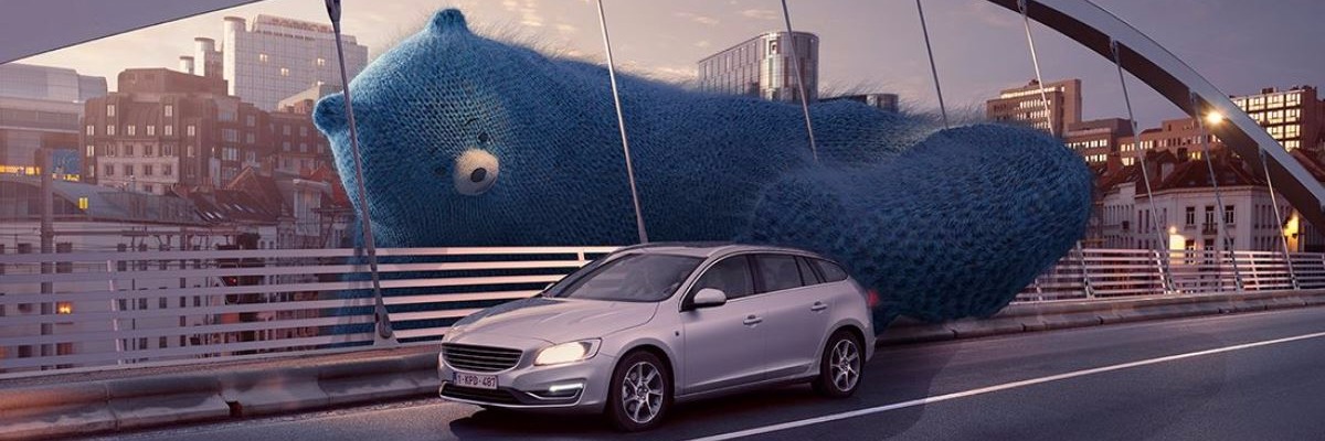 un ours bleu pousse une voiture CNG pour lui permettre de traverser un pont 