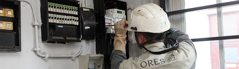 un technicien ORES en train de travailler sur un compteur